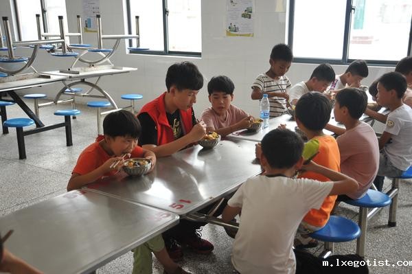 6志愿者们和孩子们一起在食堂就餐